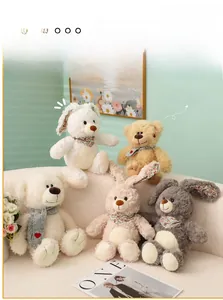 Primer plano de peluches de osos y conejos coloridos con pañuelos en un sofá blanco