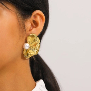 Elegant gold petal stud earring with white pearl worn by a model in a close-up shot