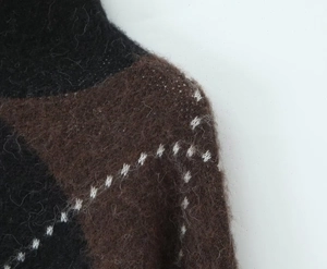 Detail of knit sweater showing black and brown argyle pattern with mohair texture