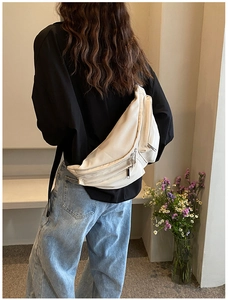 Detailed back view of a beige crossbody chest bag with wide strap and multiple zippers