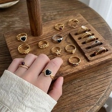 Detail shot of vintage heart and pearl ring set displayed on a tiered wooden stand