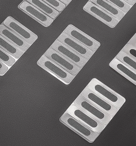 Macro detail of silver rectangular mesh drain hole covers for window screens on grey background