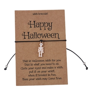 Macro shot of Halloween skull charm wish bracelet on black cord with a wish card