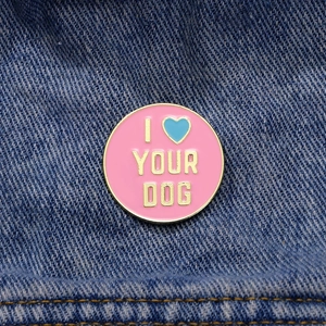 Pink enamel I Love Your Dog pin with a blue heart on denim fabric background