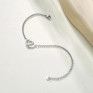 Polished silver stainless steel interlocking double ring bracelet with white zircon stones