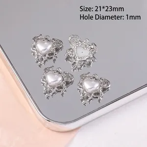 Détail macro de pendentifs coeur en métal argenté de 21x23mm avec perle et texture fluide