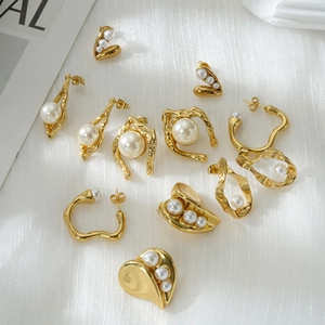 Sammlung eleganter 18 Karat Goldohrringe mit Perlen auf weißem Seidenhintergrund