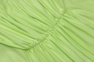 Détail macro du tissu vert clair avec texture plissée et cordon de serrage ajustable