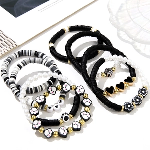 Detail of multi-layered beaded bracelet set with black and white clay heart charms