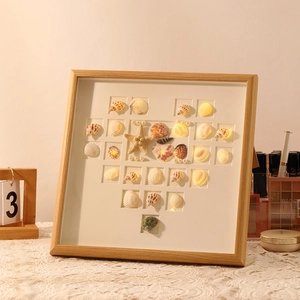 Handmade seashell heart photo frame night light with warm LED glowing on lace tablecloth
