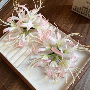 Macro shot of pink Lycoris hair clips on a jewelry display tray with elegant floral details