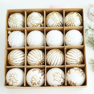 Set of 16 white and gold Christmas ball ornaments with snowflake patterns in a kraft box