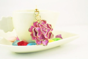 Close-up of pink enamel rose keychain with crystal accents and gold-tone metal hardware