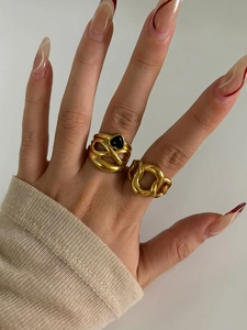 Detail of gold chain ring and black heart gemstone ring on model's hand