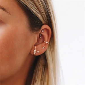 Close-up of gold S925 silver curved petal earrings with sparkling zircons on model ear