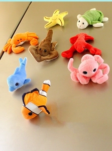 Detailed collection of eight various plush sea animal fridge magnets on a metal surface