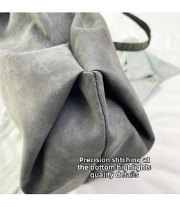Close-up of precision stitching and matte dark gray leather texture on bag bottom