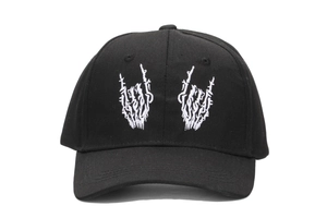 Detailed white embroidery of skull palm and rock gesture on a black cotton baseball cap