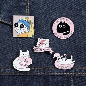 Creative enamel cat pins set featuring artistic and pop culture cat themes on denim