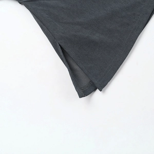 Detail view of charcoal grey knit fabric texture with a side slit on the bottom hem