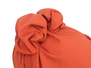 Nahaufnahme des orangefarbenen Turban-Huts mit Stoffstruktur und plissiertem Knoten