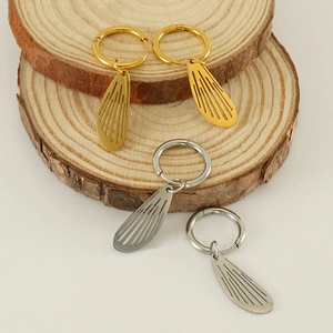 Detailed view of gold and silver hollow wing drop earrings on wooden display stands