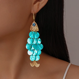 Detail of fish-shaped tassel earrings with evil eye beads and turquoise blue scales
