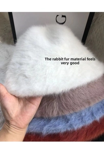 Stack of fluffy rabbit fur bucket hats in white, purple, blue and red colors