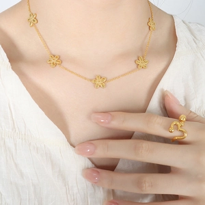 Elegant gold daisy necklace and matching bead ring set displayed on a model