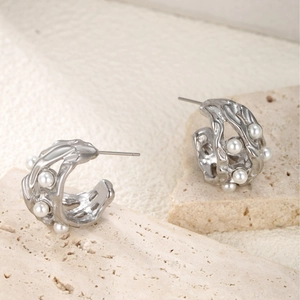 Minimalist silver hollow C-shaped earrings with pearls on natural travertine stone