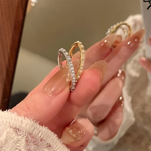 Close-up of 14K gold plated rings with embedded pearls and zircons in a wavy design
