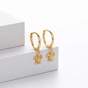 Elegant S925 sterling silver gold turtle drop earrings displayed on white geometric block