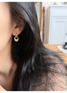 Detailansicht der goldenen ovalen Ohrringe am Model im minimalistischen Design und Finish