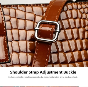 Detail of adjustable shoulder strap with silver metal buckle on brown embossed leather bag