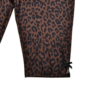 Detail of leopard print trousers with side slit and black decorative bow tie
