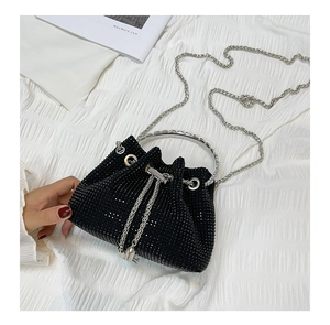 Detail of mini bucket bag with black rhinestones, metal ring handle, and silver chain strap