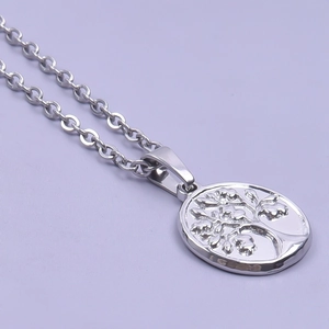 Macro detail of silver tree of life pendant on a metallic chain against purple backdrop