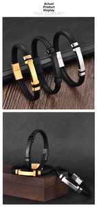 Detail of men's braided leather bracelet with gold, silver, and black metal magnetic clasps