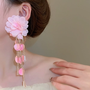 Detail shot of pink chiffon flower earrings with shimmering sequin tassels on model