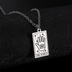 Macro shot of silver stainless steel tarot pendant necklace featuring The World etching