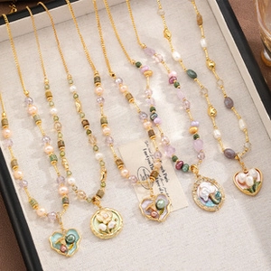 Detailed macro view of vintage pastel enamel heart and flower pendants on gold necklaces