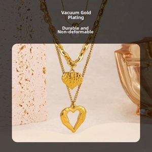 Detail view of gold layered necklace with hammered and hollow heart charms and chains