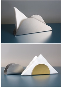 Detail view of modern mountain and semicircular stainless steel napkin holders in gold and silver