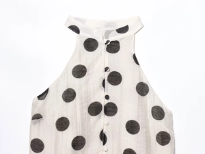 Detail of white polka dot halter top with front buttons and breathable linen texture