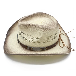 Detail of woven straw cowboy hat with brown gradient brim and leather studded band