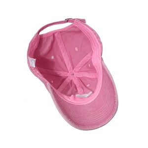 Detail view of pink washed cotton baseball cap lining with 100% cotton washing label