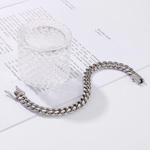 Polished silver Cuban link bracelet with diamond-encrusted clasp on aesthetic backdrop