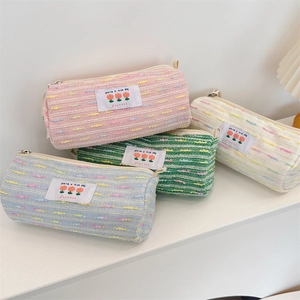 Detalle de estuches de tejido trenzado en tonos pastel con etiquetas de tulipanes