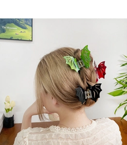 Detail showing red bat wing hair claw clip on model with gothic style aesthetic