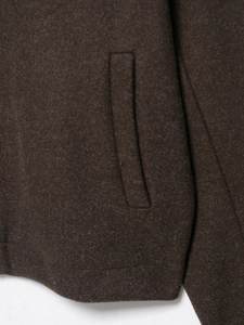 Détail des coutures sur la poche et l'ourlet de la veste en laine marron foncé